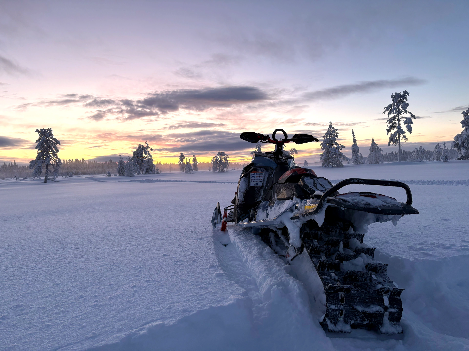 A snowmobile on an evening trail in the Ylläs fell landscape